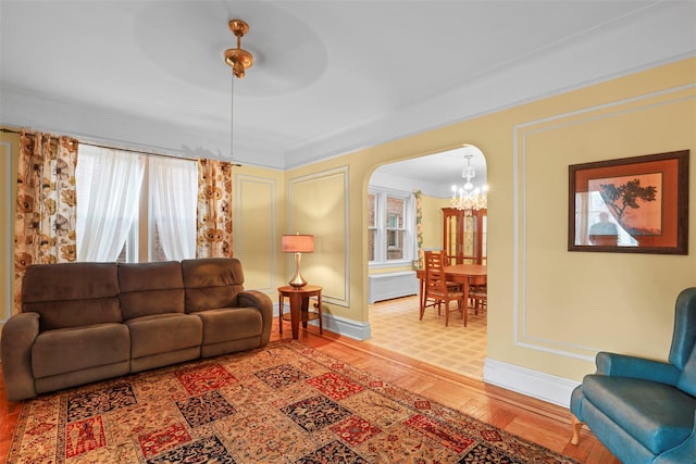 332 E 240th St, Bronx, NY 10470 - living area with a chandelier, baseboards, light wood finished floors, and arched walkways