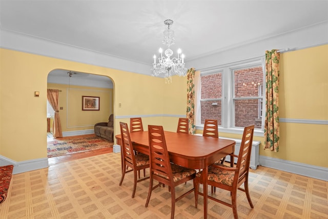 332 E 240th St, Bronx, NY 10470 - dining space featuring arched walkways, a chandelier, light flooring, and baseboards