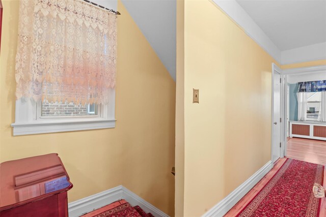 332 E 240th St, Bronx, NY 10470 - hall with radiator heating unit, wood finished floors, baseboards, and vaulted ceiling