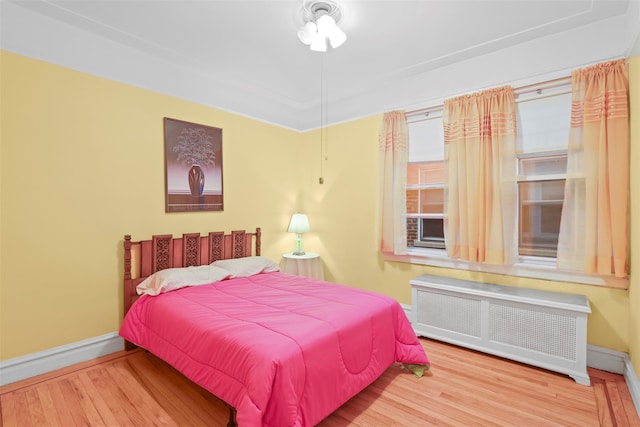 332 E 240th St, Bronx, NY 10470 - bedroom featuring radiator, wood finished floors, and baseboards