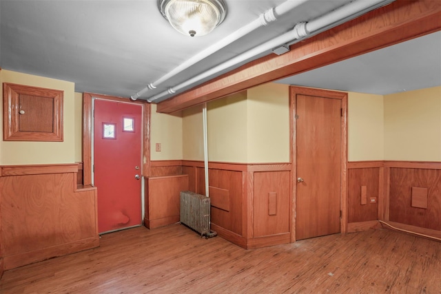 332 E 240th St, Bronx, NY 10470 - below grade area featuring radiator heating unit, wainscoting, wood finished floors, and wooden walls