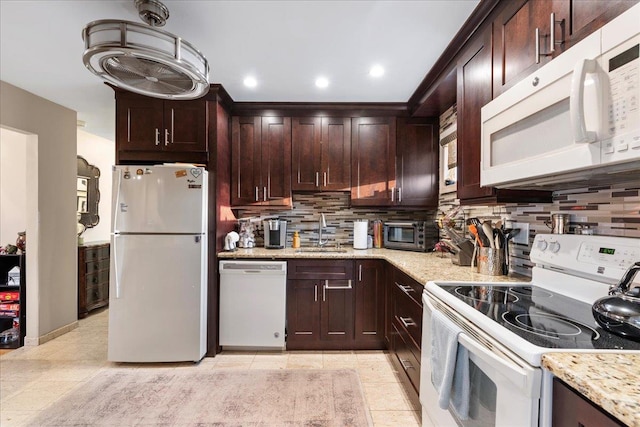 kitchen featuring white appliances, a sink, tasteful backsplash, light stone countertops, and recessed lighting