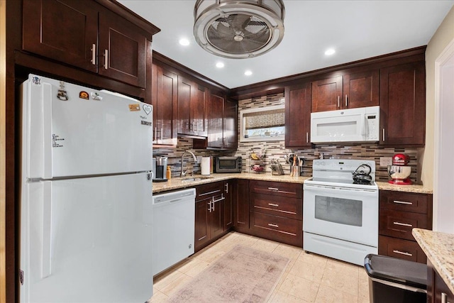 kitchen with white appliances, a sink, decorative backsplash, light stone countertops, and recessed lighting