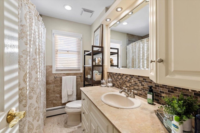 bathroom with a baseboard radiator, toilet, vanity, a shower with curtain, and tile walls
