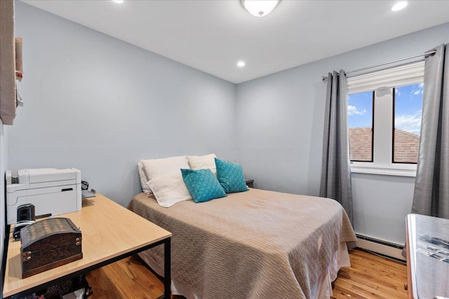 bedroom with a baseboard radiator, light wood-type flooring, and recessed lighting