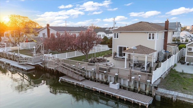 back of property featuring a fenced backyard, a water view, and a patio