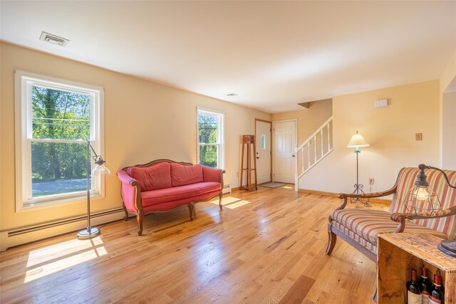 12 Prospect St, Glenham, NY 12508 - living area with a baseboard heating unit, stairs, light wood-type flooring, and baseboards
