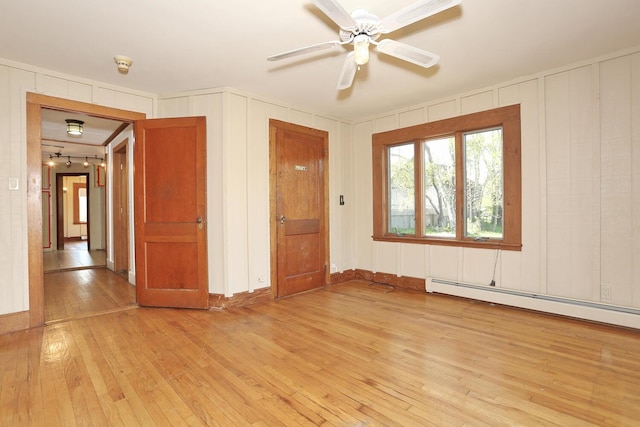 1143 State Route 17b, Mongaup Valley, NY 12762 - spare room with light wood-style floors, ceiling fan, a decorative wall, and a baseboard heating unit