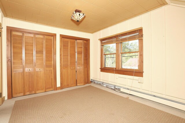 1143 State Route 17b, Mongaup Valley, NY 12762 - unfurnished bedroom featuring multiple closets, light carpet, and baseboard heating