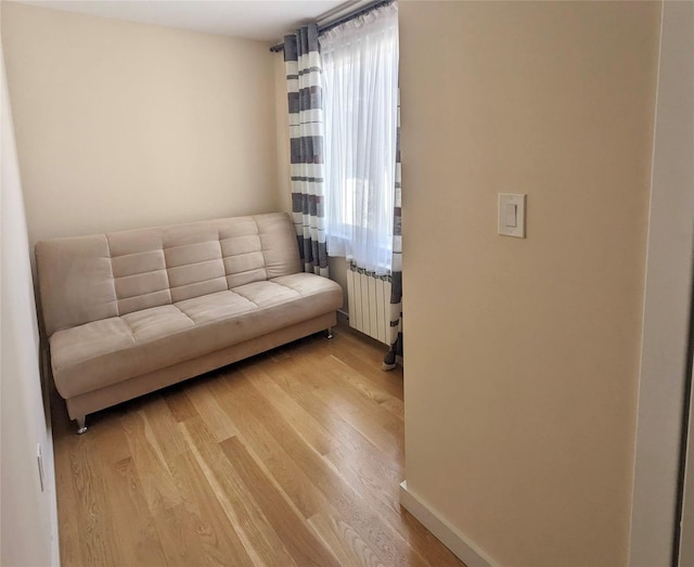 58-09 61st St, Maspeth, NY 11379 - living room featuring radiator and light wood-style flooring