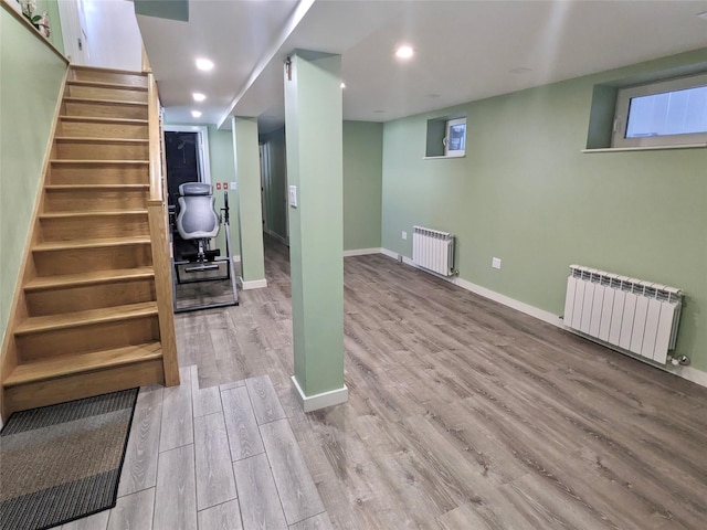 58-09 61st St, Maspeth, NY 11379 - finished below grade area featuring radiator heating unit, wood finished floors, stairway, and recessed lighting