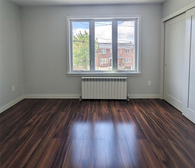 58-09 61st St, Maspeth, NY 11379 - unfurnished room with radiator, plenty of natural light, and dark wood finished floors