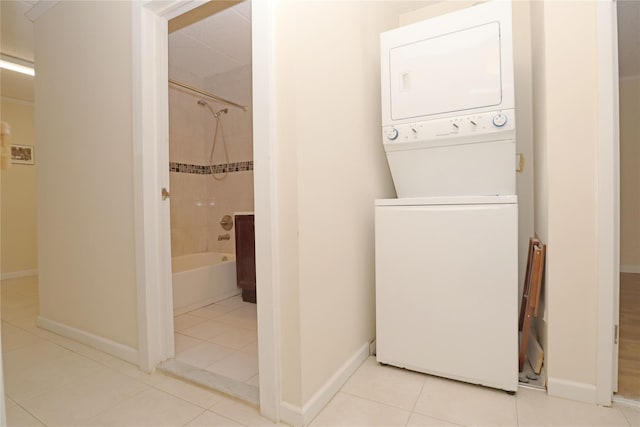 14428 Barclay Ave Unit 2C, Flushing, NY 11355 - laundry room featuring stacked washing machine and dryer, tile patterned flooring, and baseboards