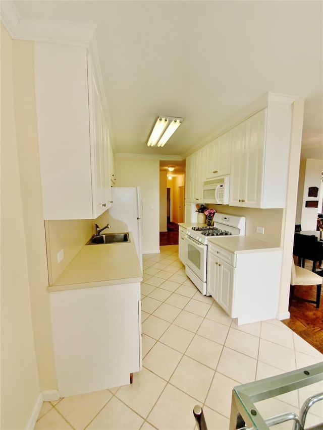 kitchen with white appliances, a sink, light countertops, and light tile patterned floors