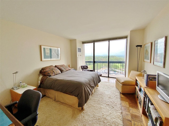 bedroom featuring access to exterior and a wall of windows
