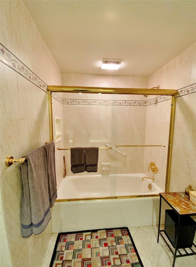 bathroom with shower / bath combination with glass door and tile walls