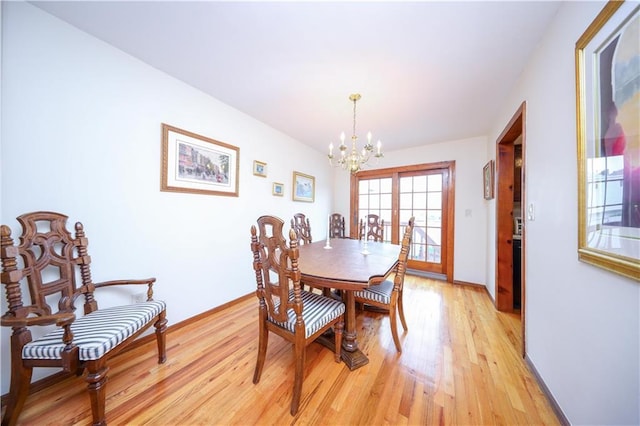 dining space featuring a chandelier, light wood-type flooring, and baseboards