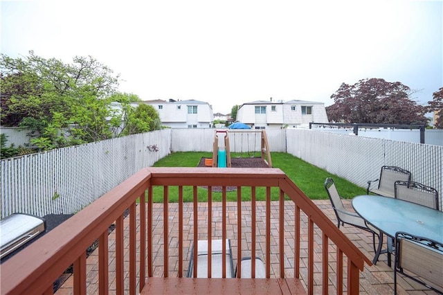 deck featuring a playground and outdoor dining area
