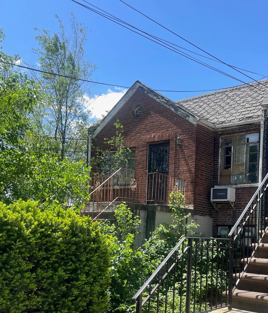 view of front of property featuring stairs and brick siding
