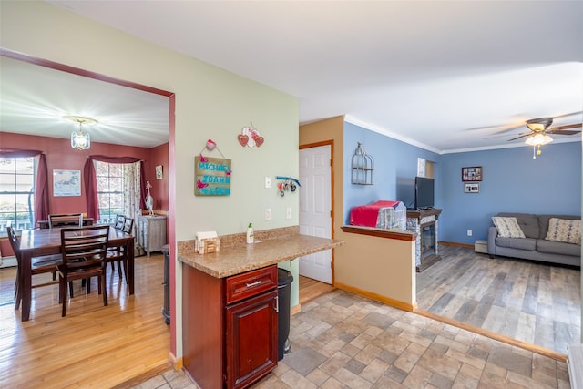 kitchen with ceiling fan, baseboards, light countertops, dark brown cabinets, and light wood finished floors