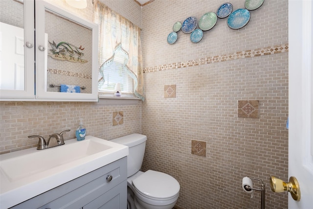 bathroom with toilet, vanity, backsplash, and tile walls