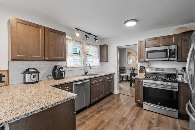 108 Homestead Ave, Maybrook, NY 12543 - kitchen featuring appliances with stainless steel finishes, a sink, decorative backsplash, and light stone countertops
