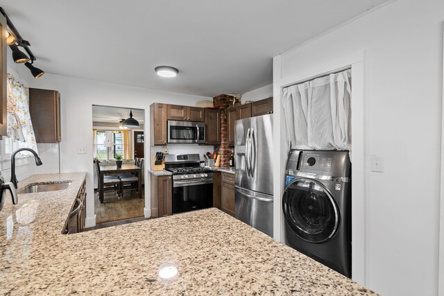 108 Homestead Ave, Maybrook, NY 12543 - kitchen featuring washer / dryer, appliances with stainless steel finishes, a sink, decorative backsplash, and light stone countertops
