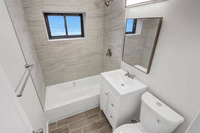 bathroom featuring plenty of natural light, toilet, vanity, and bathing tub / shower combination