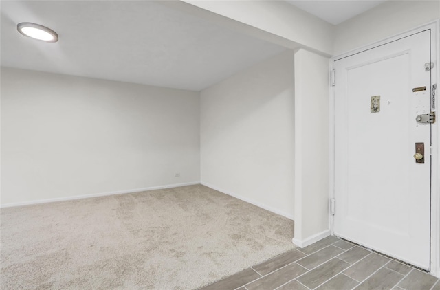entryway featuring baseboards and carpet floors