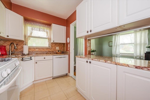 kitchen with white appliances, white cabinets, decorative backsplash, and light stone countertops