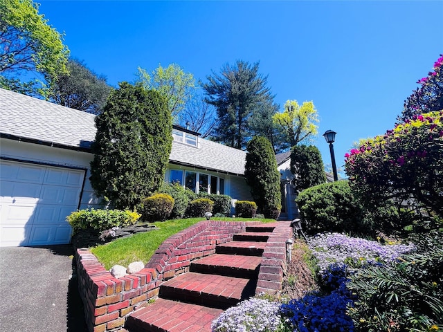 21 Rivers Dr, Great Neck, NY 11020 - view of front facade with roof with shingles and a garage