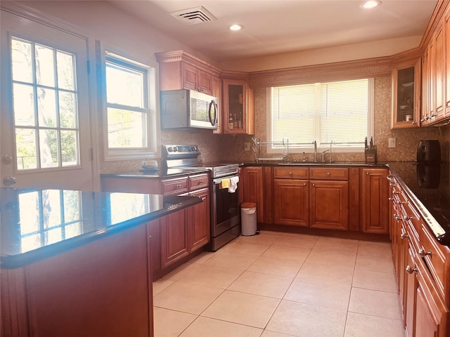 21 Rivers Dr, Great Neck, NY 11020 - kitchen with stainless steel appliances, a sink, brown cabinetry, glass insert cabinets, and recessed lighting