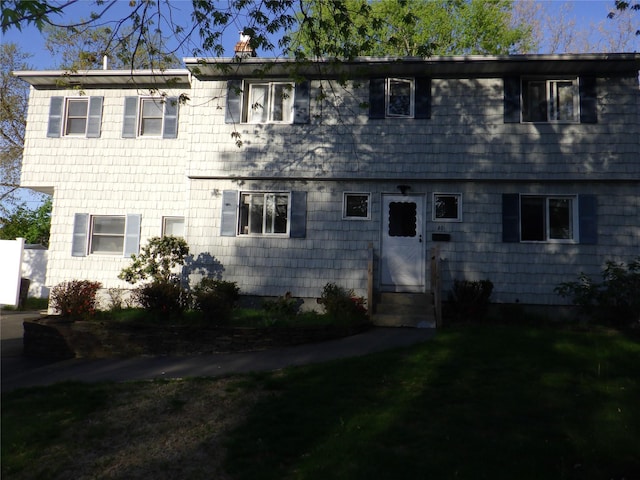 view of front of home with a front lawn and a chimney