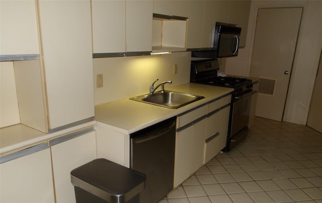 kitchen with black appliances, a sink, light countertops, white cabinetry, and light tile patterned flooring