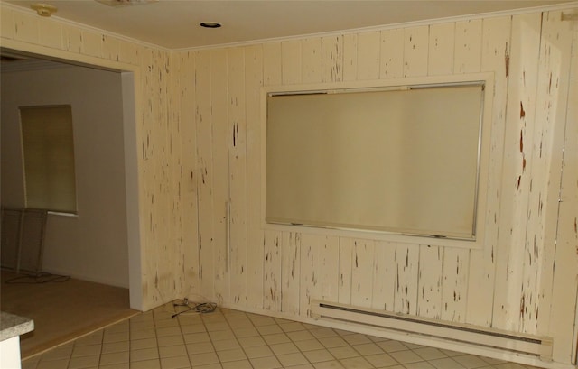 tiled empty room featuring baseboard heating, ornamental molding, and wooden walls