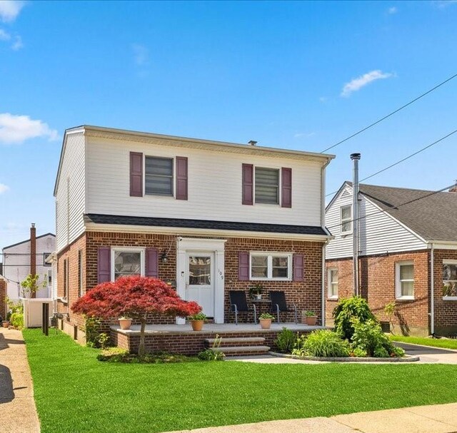 109 Wilton St, New Hyde Park, NY 11040 - view of front of home featuring a front lawn and brick siding