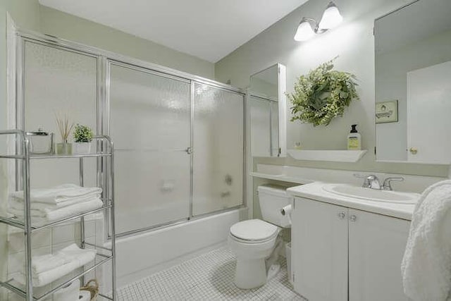 141 Southgate Dr, Massapequa Park, NY 11762 - bathroom featuring vanity, toilet, tile patterned flooring, and combined bath / shower with glass door