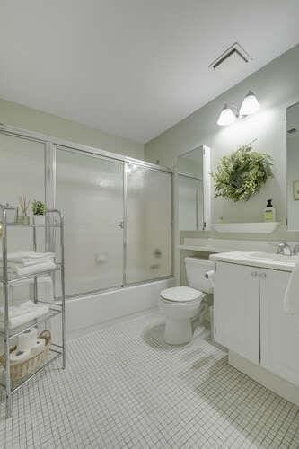 141 Southgate Dr, Massapequa Park, NY 11762 - bathroom with enclosed tub / shower combo, toilet, and vanity