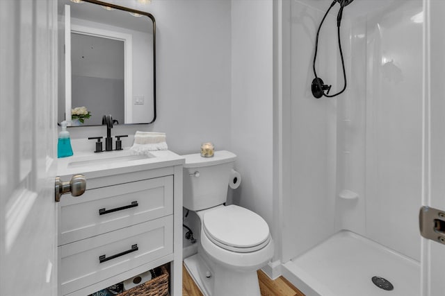 full bathroom with a stall shower, toilet, vanity, and wood finished floors