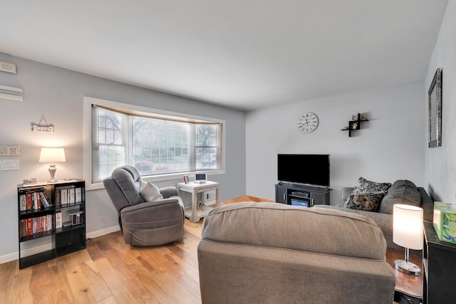 187 Mark Tree Rd, Centereach, NY 11720 - living room featuring light wood-style flooring, an AC wall unit, and baseboards