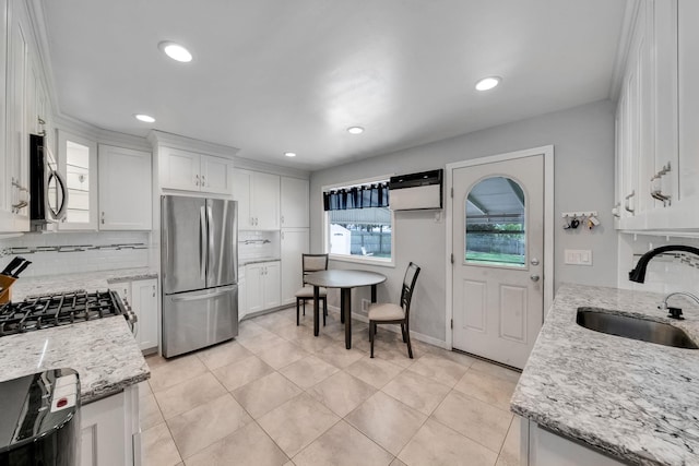 187 Mark Tree Rd, Centereach, NY 11720 - kitchen featuring appliances with stainless steel finishes, a sink, tasteful backsplash, white cabinetry, and light stone counters