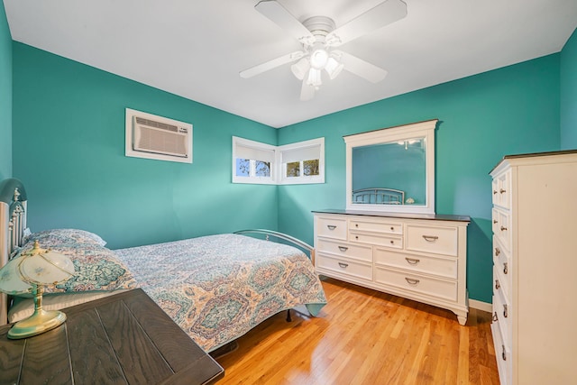 187 Mark Tree Rd, Centereach, NY 11720 - bedroom featuring an AC wall unit, light wood-style floors, ceiling fan, and baseboards
