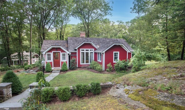 view of front of home featuring a chimney and a front lawn