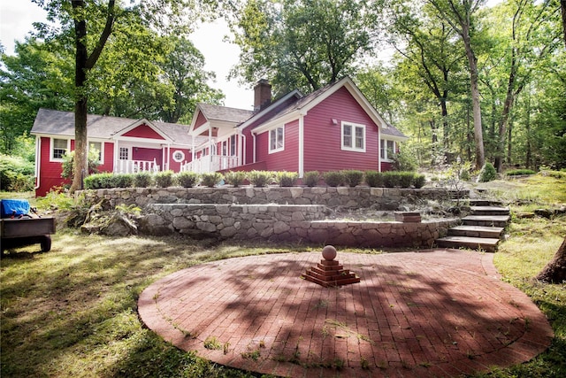 rear view of house with a chimney and a patio