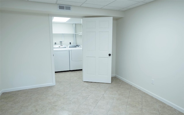 laundry room with washer and clothes dryer, baseboards, and light tile patterned floors