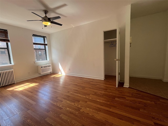 215-44 47th Ave Unit 2B, Bayside, NY 11361 - unfurnished bedroom featuring wood finished floors, radiator, a wall mounted AC, and baseboards