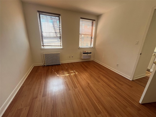 215-44 47th Ave Unit 2B, Bayside, NY 11361 - spare room with radiator heating unit, plenty of natural light, wood finished floors, and baseboards