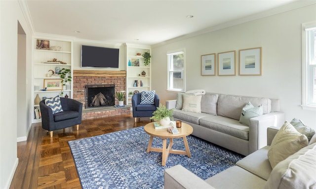 living area with a brick fireplace, crown molding, built in features, and baseboards
