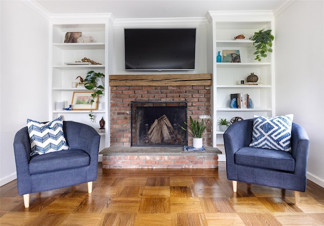 living area with a brick fireplace, built in shelves, ornamental molding, and baseboards