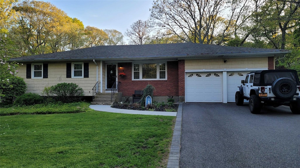 ranch-style house with an attached garage, a front yard, driveway, a shingled roof, and entry steps